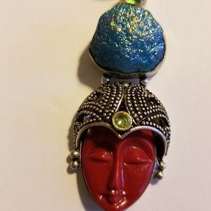 Intricately carved red face pendant